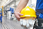 Gelber Arbeitshelm und Handschuhe